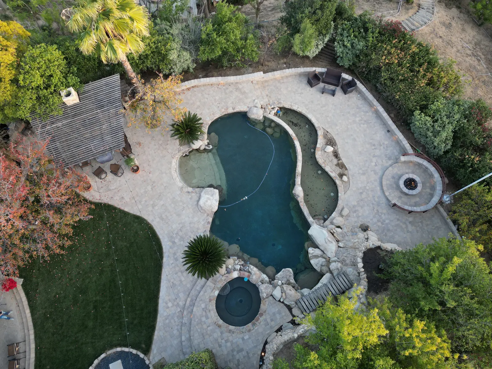 Top-down drone photo of the finished lagoon pool, spa, fire pit and paver patio