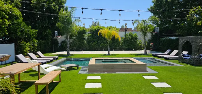 Pool and raised spa with turf, stepping pads and string lights